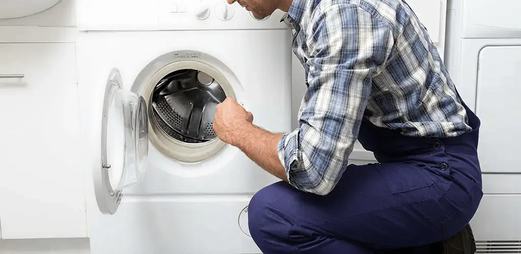 Handyman inspecting a dryer drum and internal parts for repair in Orlando, FL