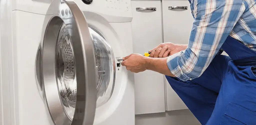 Handyman repairing a clothes dryer and checking electrical connections in Orlando, FL