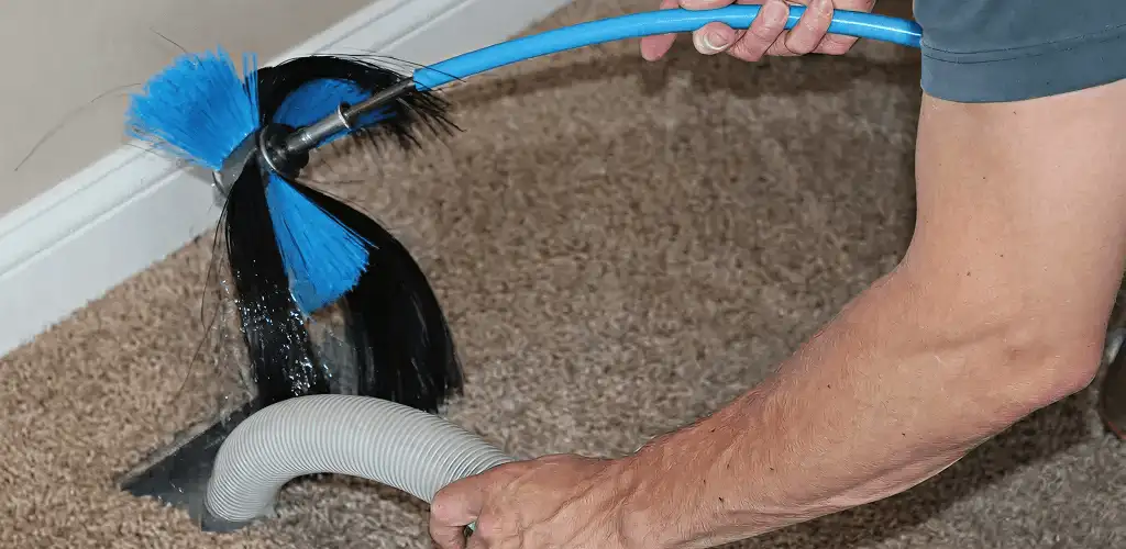 Dryer vent cleaning technician brushing lint from a vent line in Orlando, FL