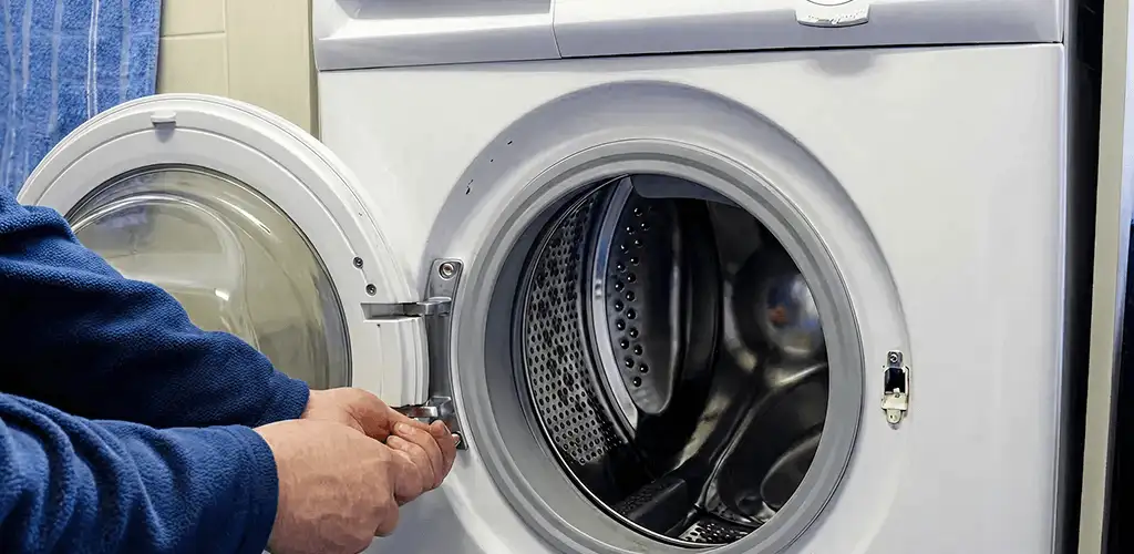 Washing machine repair handyman checking a front-load washer door and latch in Orlando, FL