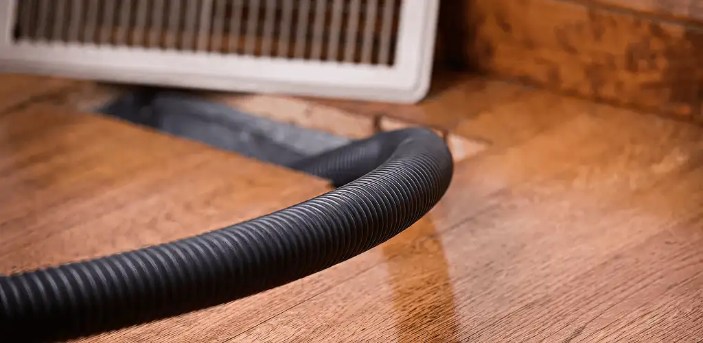 Air duct cleaning hose inserted into a floor vent for ductwork cleaning in Orlando, FL