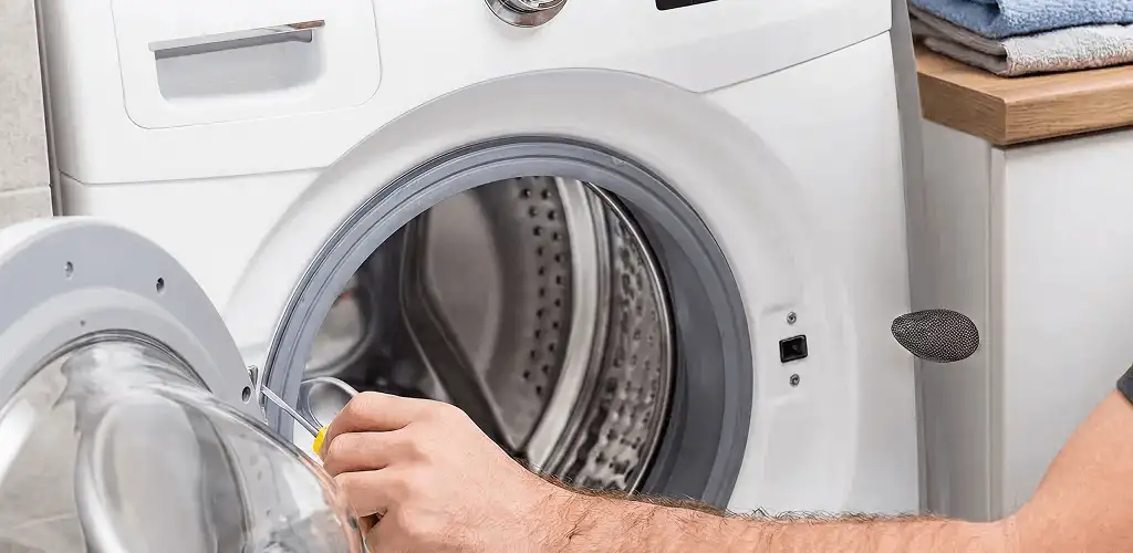 Handyman repairing a front-load washing machine and inspecting the drum in Orlando, FL