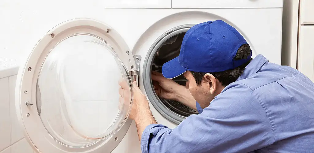 Washing machine repair handyman inspecting a front-load washer drum in Orlando, FL