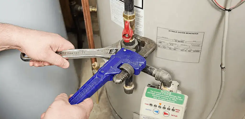 Water heater repair technician tightening the shutoff valve and supply line in Orlando, FL